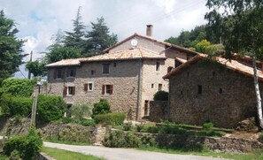 A stone building with a tiled roof, surrounded by greenery and a stone wall. - Cottage 'Joannet' with Mountain View, Private Terrace and Wi-Fi (Lamastre)