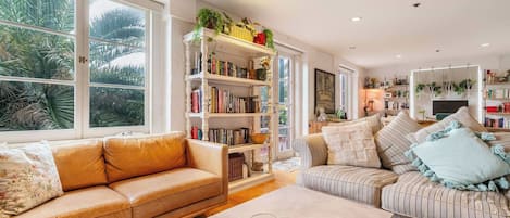 A living room with a sofa, a coffee table, and a bookshelf.