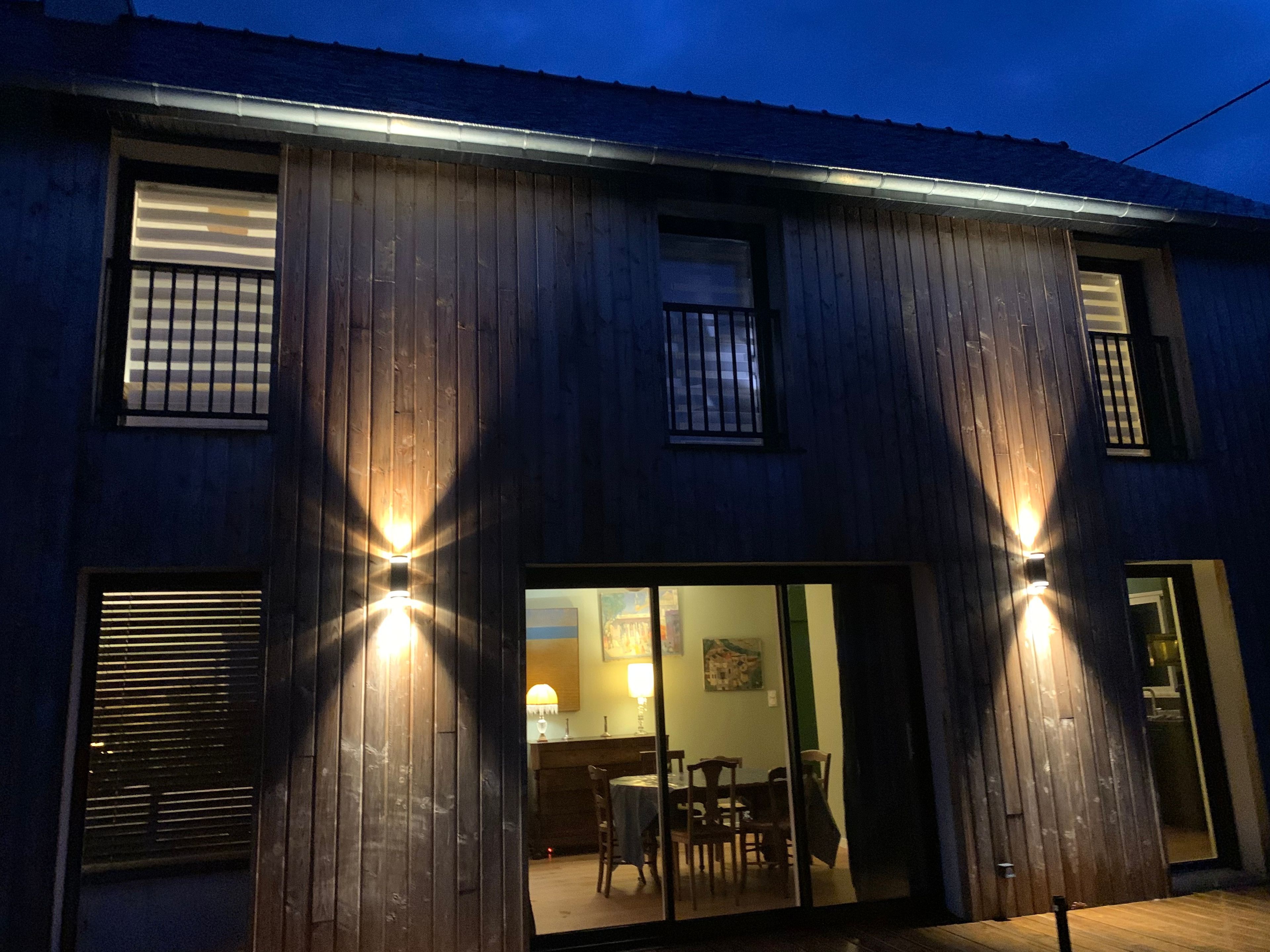 Un bâtiment à deux étages, avec un revêtement en bois et un balcon.