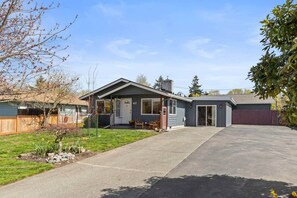 Ein eingeschossiges Haus mit Garage, überdachter Veranda und Vorgarten.