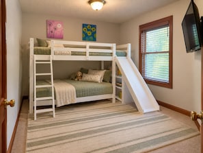 A bunk bed with a slide, a window with blinds, and artwork on the wall. - Wooded Acre Retreat near Wright-Patt w/ Game Room (Xenia)