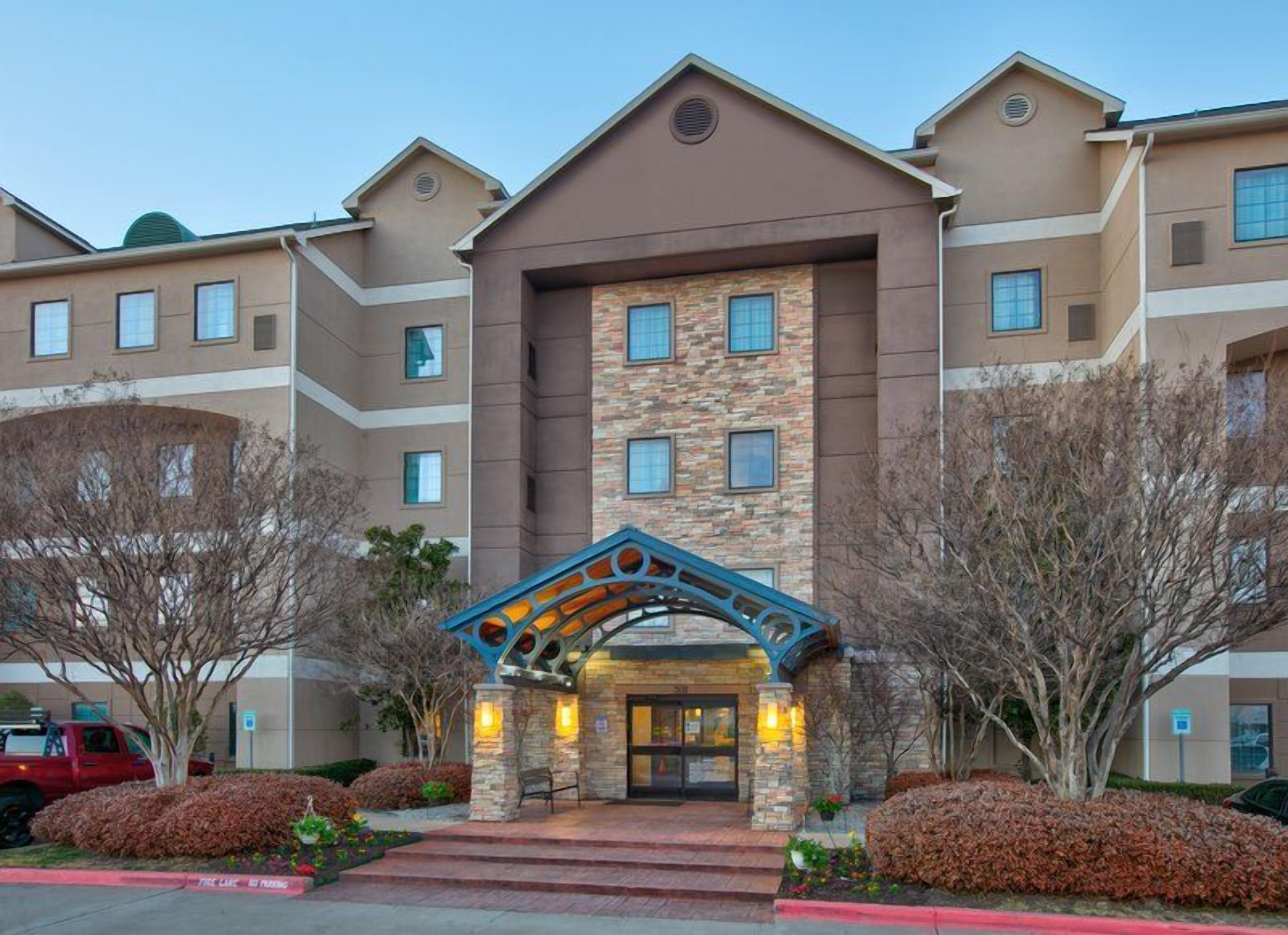 Welcoming entrance with landscaped facade and covered awning