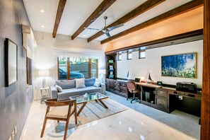 A modern living room with a glass coffee table, a sofa, and a desk area with a computer. - Magnificent Canal House w/ Dock & Adjacent Golf (Nuevo Vallarta)