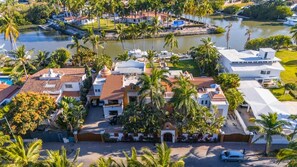 A coastal property with multiple buildings, a marina, and palm trees. - Magnificent Canal House w/ Dock & Adjacent Golf (Nuevo Vallarta)