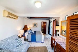 A hotel room with a bed, a sofa, a desk, and a mirror. - Magnificent Canal House w/ Dock & Adjacent Golf (Nuevo Vallarta)