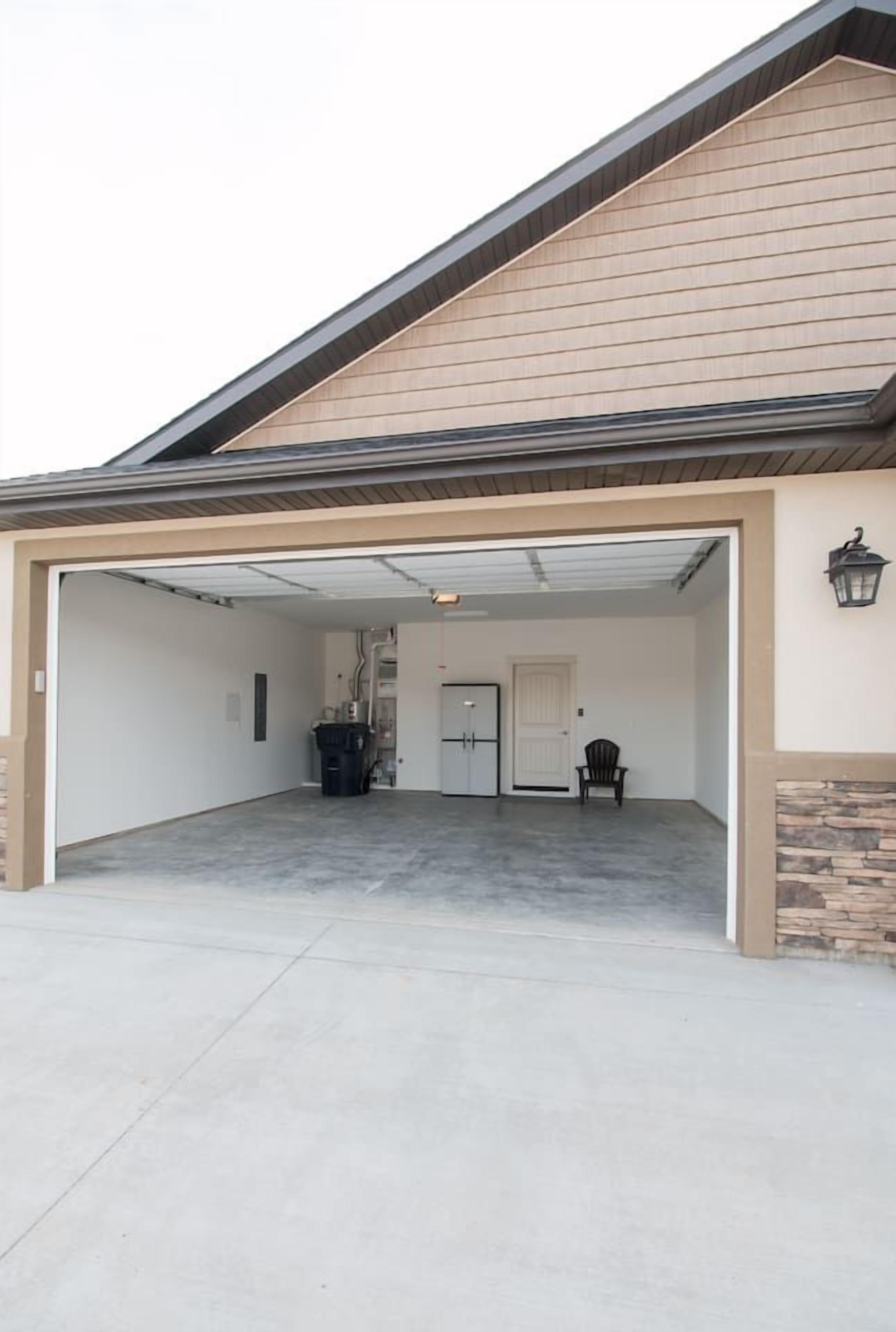 A garage with a covered entrance, a door, and a chair.