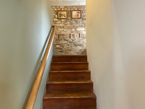 Eine Holztreppe mit einer Steinwand oben.
