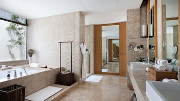 Une salle de bain moderne avec un grand miroir, deux lavabos, une baignoire et une douche à l’italienne.