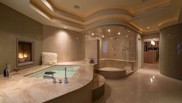 Une salle de bain luxueuse avec un lavabo en marbre, une baignoire et un espace douche séparé.
