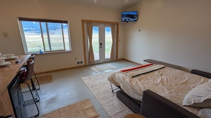 A bedroom with a bed, a desk, and a TV. - Amazing Views b/t Yellowstone and Livingston, Quiet & Private (Livingston)