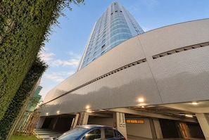 A modern building with a glass facade and a parking garage below. - Edf Praia de Gameleira (Recife)