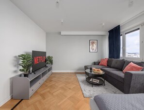 A modern living room with a flat-screen TV, grey sofa, and a coffee table. - Spacious Apartment in Central Warsaw (Warsaw)