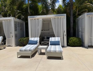 Two lounge chairs with cushions, a small table, and a covered seating area with curtains. - Kovay Gardens 2BR by Monyxbnb (La Cruz de Huanacaxtle)