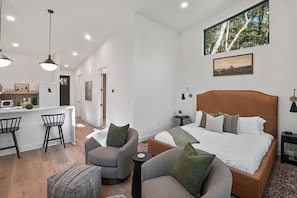 Ein modernes Hotelzimmer mit einem großen Bett, einem Schreibtisch und einer Sitzecke.