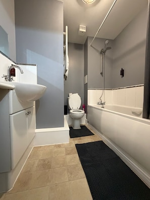 A bathroom with a sink, toilet, and bathtub. - Jacobs court 47 (Crawley)
