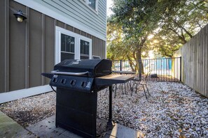 A barbecue grill in a backyard with a house, a tree, and a fence. - 4BR Corolla Light Retreat w/ Hot Tub & Game Room (Corolla)