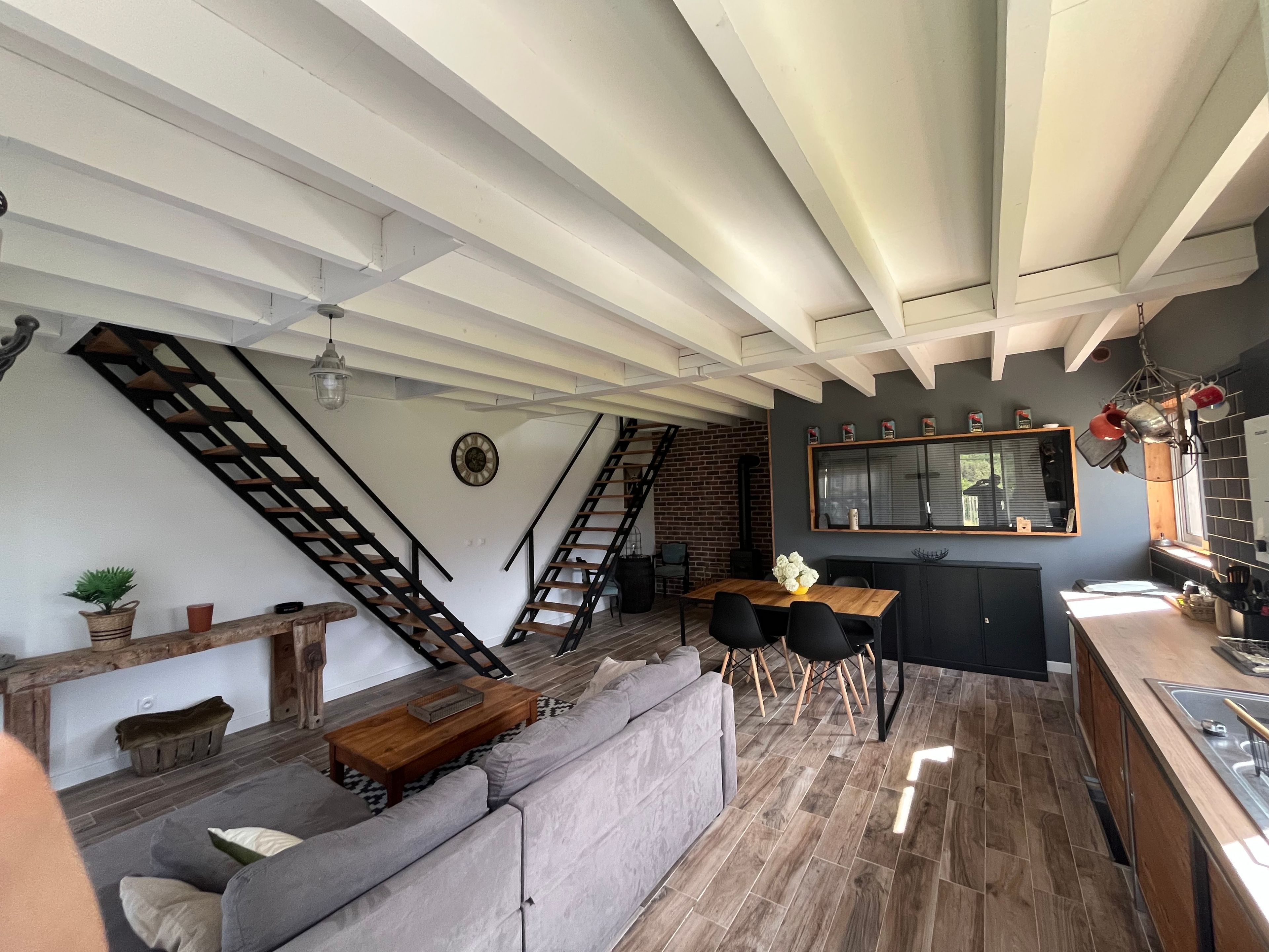 A modern interior with a staircase, a dining area, and a kitchen.