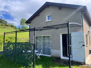Ein Haus mit überdachter Terrasse, einer Schiebetür und einer weißen Garagentür.
