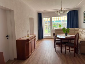 A dining area with a wooden table, chairs, a cabinet, and a sofa. - New Listing (Thaling)
