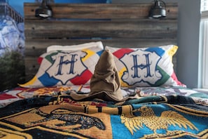 A bed with a colorful blanket and pillows with a letter 'H' design. - Mickey Magic and Harry Potter Pool Retreat (Davenport)