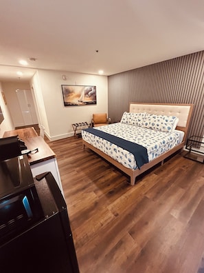 Un dormitorio moderno con una cama grande, un escritorio y una silla.