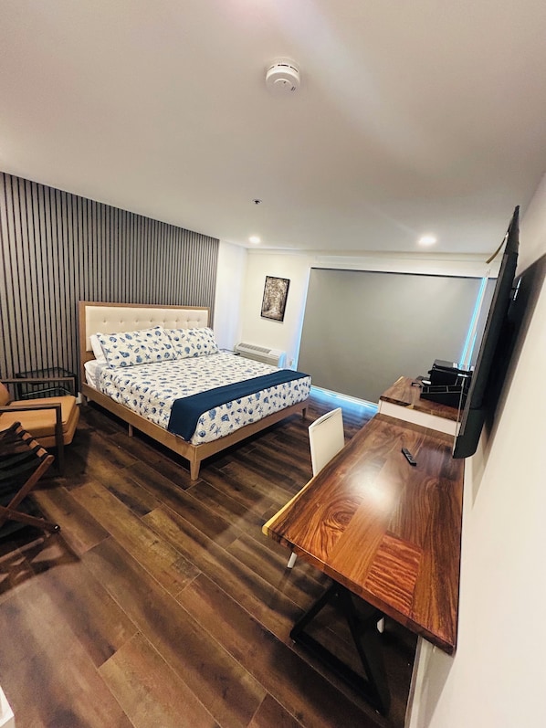 Un dormitorio con cama, escritorio y silla.