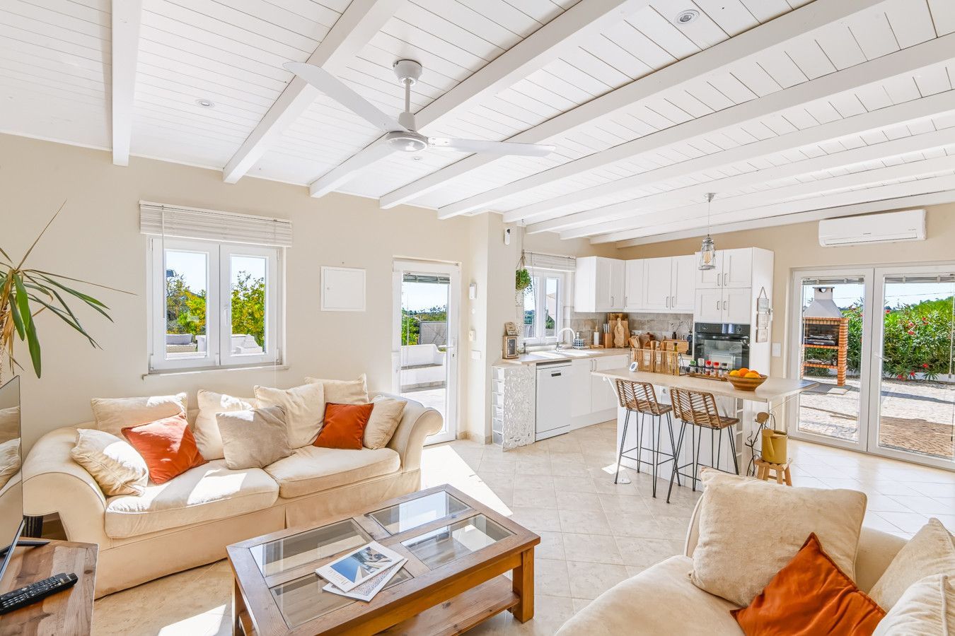 A spacious living area with a sofa, coffee table, and a kitchen with a bar area.