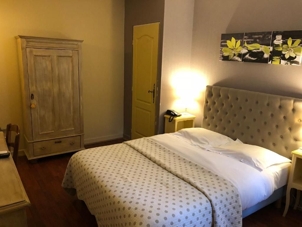 Ein Schlafzimmer mit einem Bett, einem Kleiderschrank, einem Nachttisch und einer Wandleuchte.
