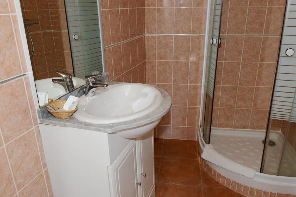 Ein Badezimmer mit Waschbecken, Spiegel und Dusche.