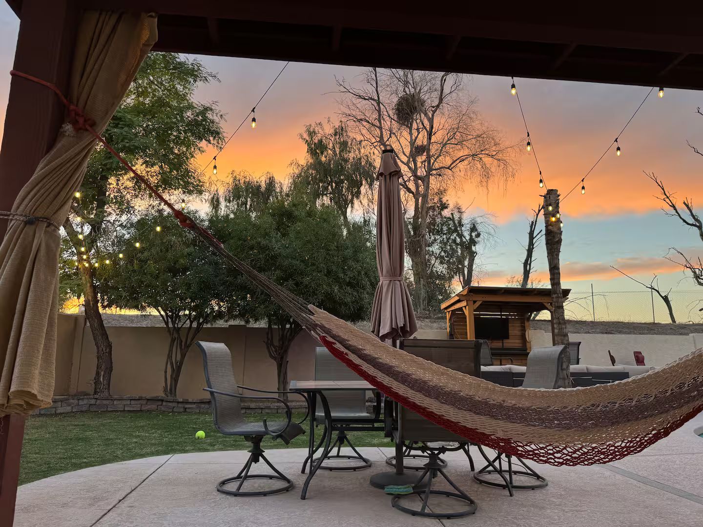 A hammock, patio furniture, and a sunset view.