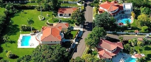 Un barrio residencial con varias casas, una piscina y un césped bien cuidado.