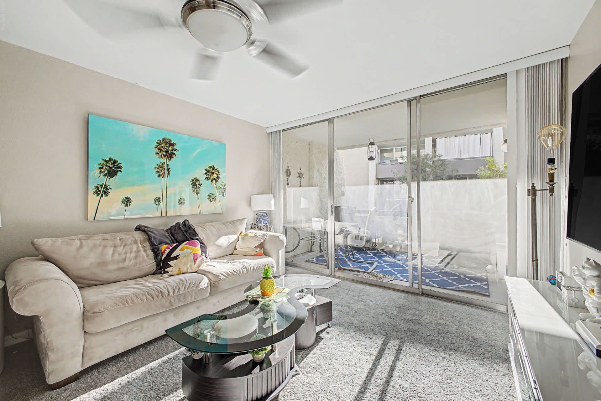 A living room with a sofa, coffee table, and artwork on the wall.