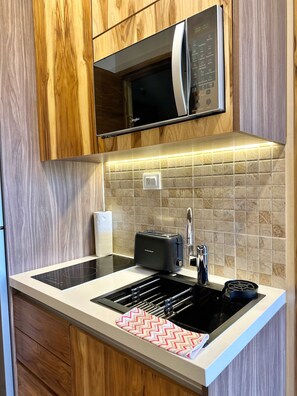 Eine moderne Küche mit integriertem Mikrowellenherd, Induktionskochfeld und Toaster.