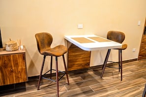 A dining area with a white table and two chairs, a woven basket, and a small vase with reed sticks. - Hamaca  Calma y Dise  o  Eco-chic Boutique Stay (Playa del Carmen)