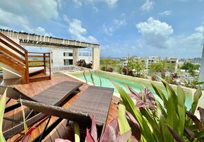 A rooftop pool area with lounge chairs and a view of the cityscape. - Estudio Moderno Caribe  o  con Vista al Mar (Playa del Carmen)