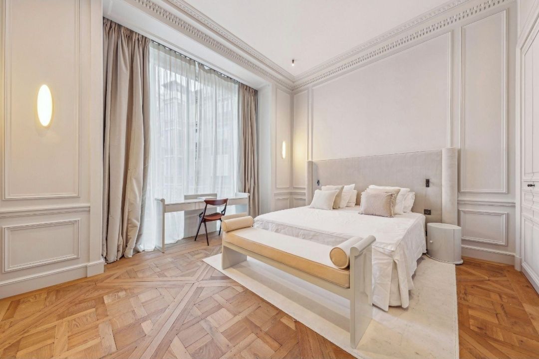 Een hotelkamer met een groot bed, een bureau en een stoel.