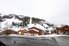 A snow-covered mountain village with wooden buildings and a clear sky. - Apartment 'La parenthèse Alpine' with Mountain View, Shared Pool and Balcony (La Plagne Tarentaise)
