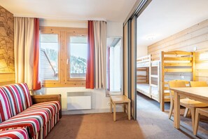 A cozy room with a sofa, a table, and bunk beds.