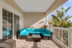 A covered outdoor seating area with a sectional sofa and wicker furniture. - Luxurious Reunion Three Bed, Three Bath - SR001 (Four Corners)