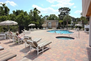 A pool area with lounge chairs and umbrellas, a hot tub, and a brick patio. - Sweet Main Floor Home in Sweetwater - SW001 (Kissimmee)