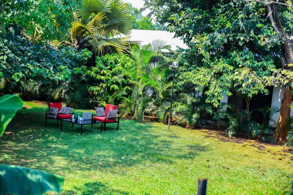 A lush garden with a seating area featuring a table and chairs.
