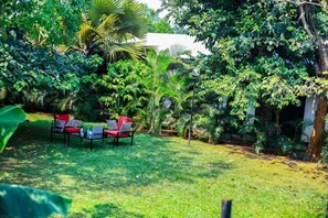 Un exuberante jardín con una zona de estar que incluye una mesa y sillas.