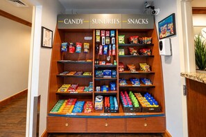 A candy, sundries, and snacks vending machine with various brands and prices. - ADA Suite w/ Kitchen | Free Breakfast & Shuttle (Houston)
