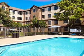 A swimming pool with a no diving sign, a lifeguard duty warning sign, and a fenced patio area with outdoor furniture. - ADA Suite w/ Kitchen | Free Breakfast & Shuttle (Houston)