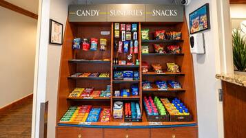 A candy, sundries, and snacks vending machine with various brands and prices.