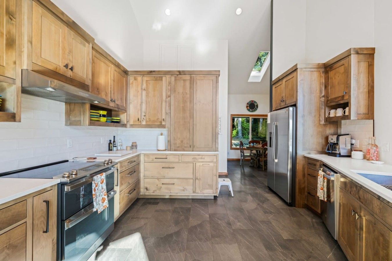 A modern kitchen with wooden cabinets, stainless steel appliances, and a central island.