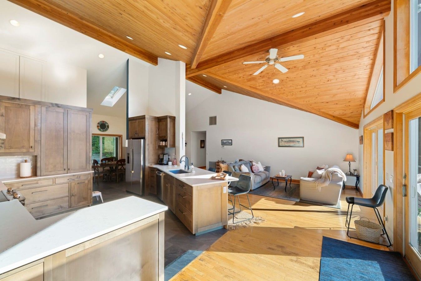 A spacious kitchen with wooden cabinets, a central island, and a ceiling fan.