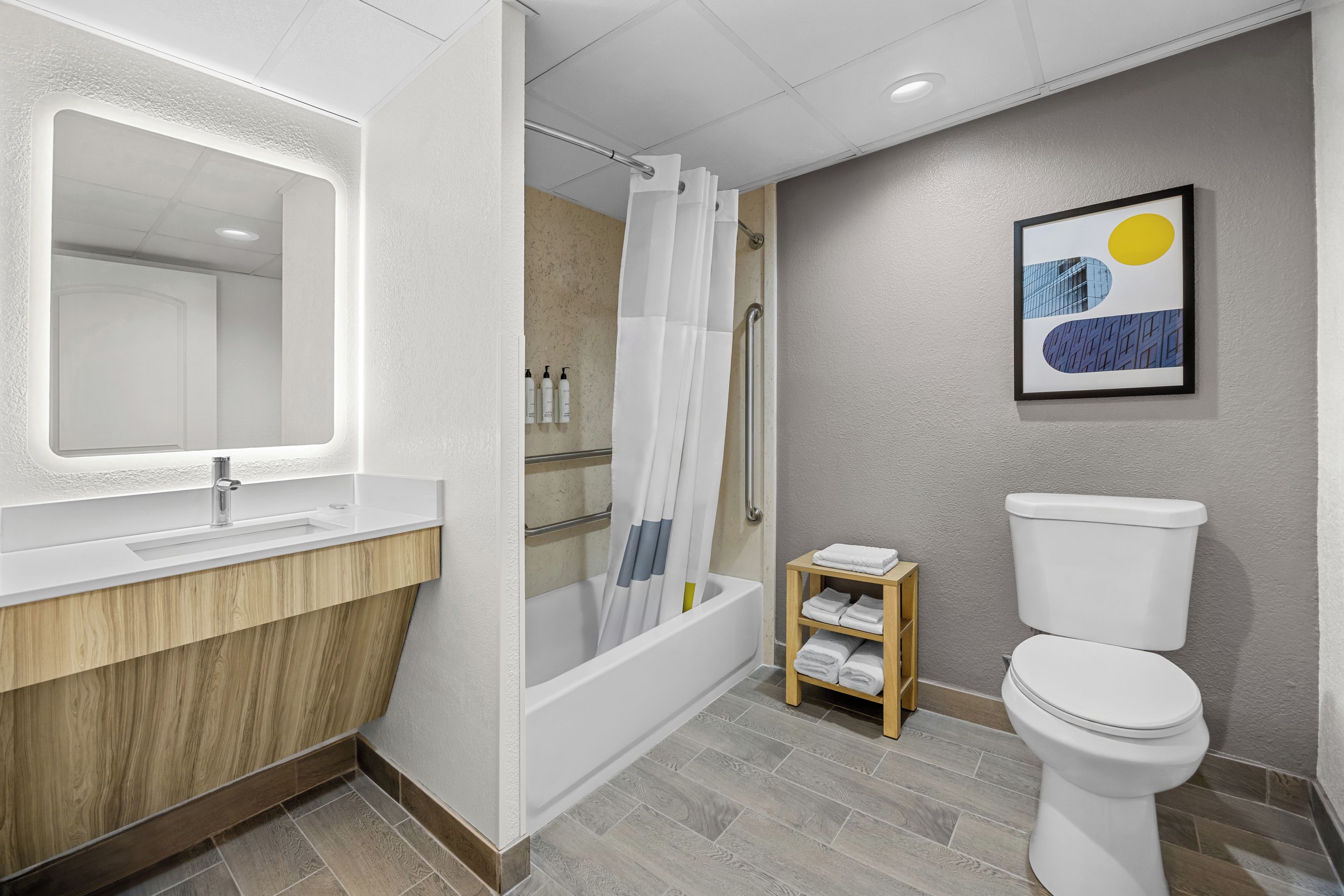 Un baño moderno con bañera, inodoro y tocador.