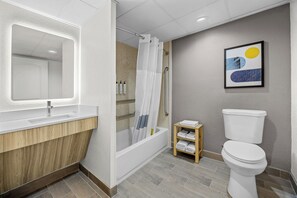 Un baño moderno con bañera, inodoro y tocador.