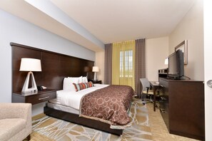 A hotel room with a large bed, a desk, a chair, a television, and a lamp. - Accessible 2BR Suite w/ Daily Hot Breakfast + Pool (San Antonio)